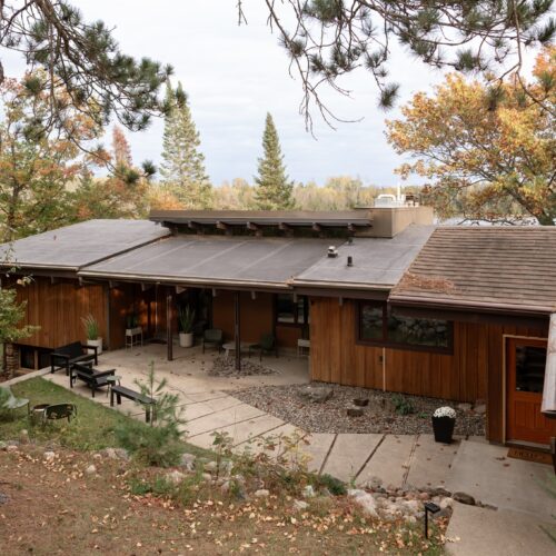 Mid-Century lines and a welcoming front patio with modern seating—your Northwoods retreat starts here.