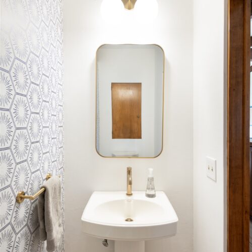 A simple, stylish half bath with mid-century character off of the kitchen.